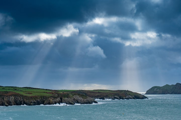 Shafts of light over a coastal landscape