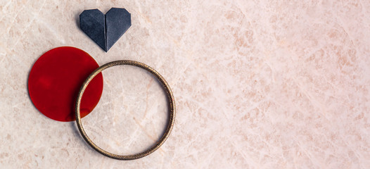 Origami hearts, ring and circle on a marble background with text space. Valentine's day concept.