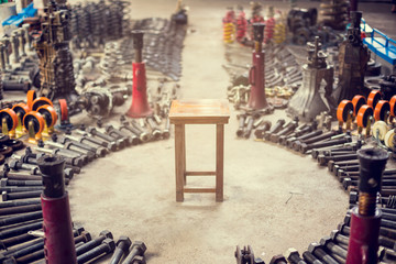 Wooden chair surrounded by many tools and old auto spare parts car at a car repair shop. Car parts...