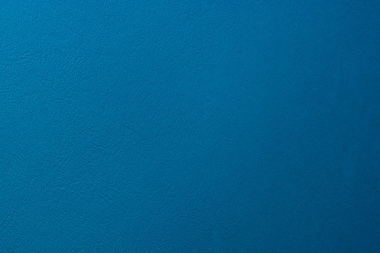 Textured background of matte wall of blue colour