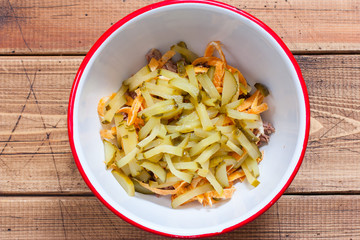 Step-by-step preparation of salad with boiled beef and egg pancakes, step 3 - adding chopped pickles to the salad, top view, horizontal
