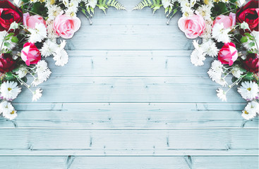 Big beautiful decorative composition of flowers on a blue wooden table. Top view, background with copy space for your text. Red and pink roses, white daisies.