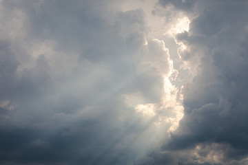 Fototapeta na wymiar Sunbeam between storm clouds cloudscape sky