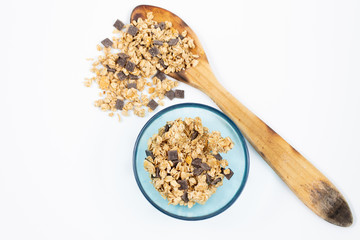 Wooden spoon with cereals on white background with bowl of cereals