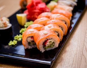 Sushi set. Rolls with salmon, eel and red caviar on a wooden plate. Restaurant.