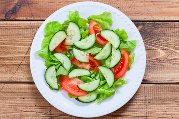 Step-by-step cooking of salad with tuna and fresh vegetables, step 4 - adding chopped fresh cucumbers to the salad, top view