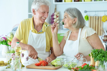 Portrait of senior couple cooking together at kitchen