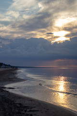 Sea ocean landscape at sunset with volumetric light (god rays) Baltic shore coast at dusk