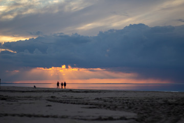 Sea ocean landscape at sunset with volumetric light and human silhouette (god rays) Baltic shore coast at dusk