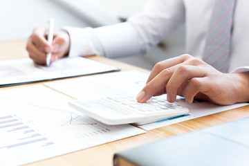 Fototapeta premium Businessmen use graphs to summarize results and calculate income-expenses to find financial balance points and use them to improve and advance business, finance and economic concepts.