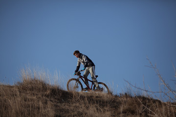 Silhouette of sports person cycling on the field
