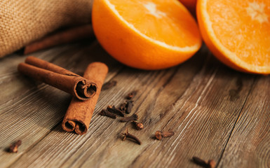  Cinnamon sticks and halves of oranges on an old wooden table copy space. Spices for mulled wine.