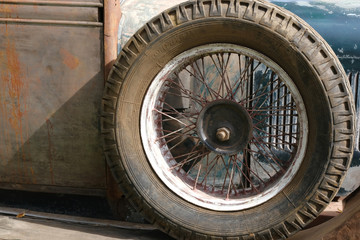 Spare wheel on old rusty vintage classic car close up