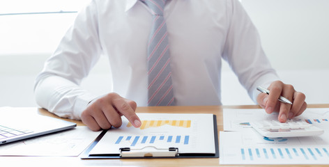  Businessmen use graphs to summarize results and calculate income-expenses to find financial...