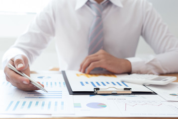  Businessmen use graphs to summarize results and calculate income-expenses to find financial balance points and use them to improve and advance business, finance and economic concepts.