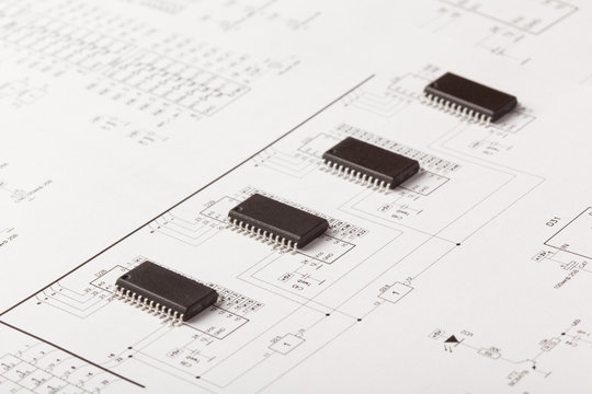 Closeup Photo Of Microcircuit Chips On Drawing Of An Electronic Device On White Background