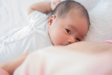 Newborn baby sucking breast milk