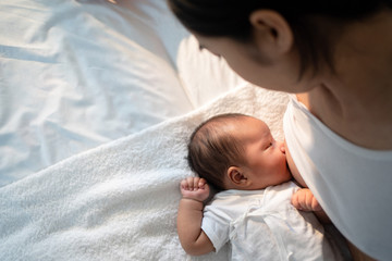 Obraz na płótnie Canvas Newborn baby sucking breast milk