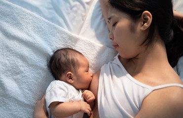 Newborn baby sucking breast milk