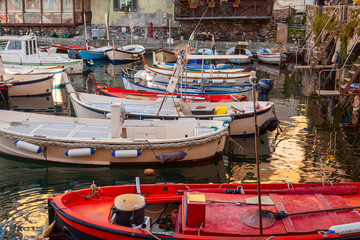 View of the fishing port of Camogli with some fishing boats berthed, waiting for fishing work time. Camogli is a small fisherman village on the shores of the Ligurian Sea. (Northern Italy)