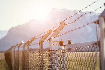 Military fence with barbed wire. Restricted area.