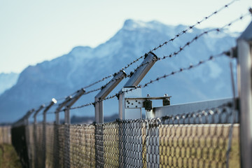 Military fence with barbed wire. Restricted area.