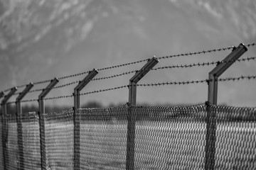 Military fence with barbed wire. Restricted area.