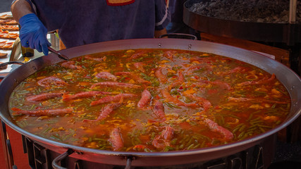 rice and seafood paella in foreground on paellero..