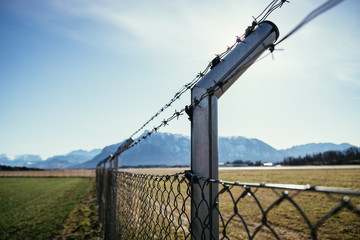 Military fence with barbed wire. Restricted area.