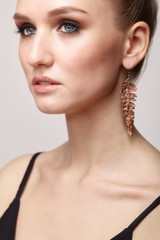 Beautiful woman with galvanic earring in form of leaf