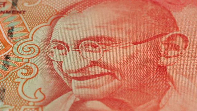 Mahatma Gandhi portrait on India 20 rupee banknote rotating. Low angle, macro. 4K, 422 10 bit