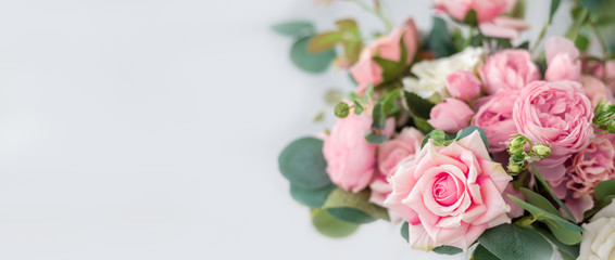 Beautiful rose flowers on a light background. Floral frame in soft colors with white space for...