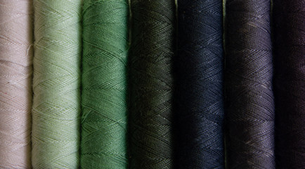 Reels of green and blue cotton yarn in close up