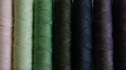 Reels of green and blue cotton yarn in close up