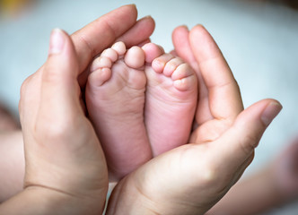 Infant heels in mother's hands.