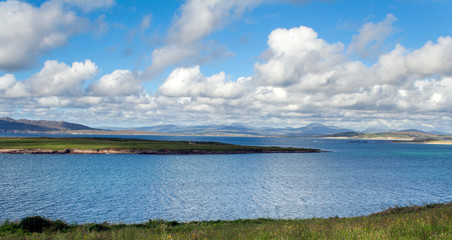Beautiful Irish seascape on a sunny day with blue sky and dramatic clouds