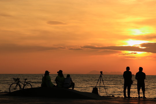 Silhouette photographers  waiting to take pictures of the sunrise on the beach at dawn