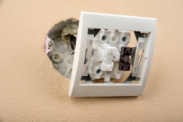 White electric switch with on a wall and without cover