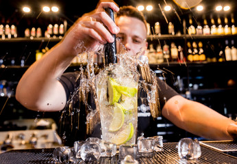 Bartender is making cocktail at bar counter. Fresh cocktails. Barman at work. 