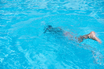 Boy in diving mask swim underwater in the swimming pool