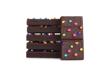stack of chocolate fudge brownies with candy pieces on white