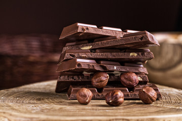Chocolate bar with hazelnut on a wooden background.