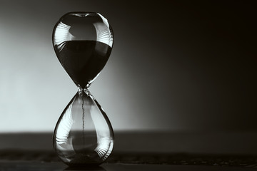 Hourglass on the dark background with copy space. Concept of running out of time and deadline