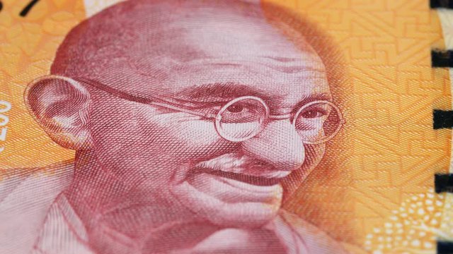 Mahatma Gandhi portrait on India 200 rupee banknote rotating. Low angle, macro. 4K, 422 10 bit