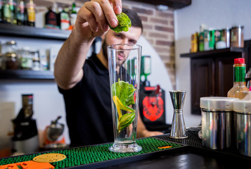 Bartender is making non alcoholic cocktail at bar counter. 