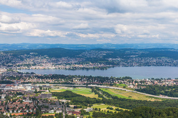 Aerial panorama view of Zurich cityscape skyline and Zurich lake from top of Uetliberg mountain on a cloudy summer day with beautifil cloudscape in sky, Switzerland