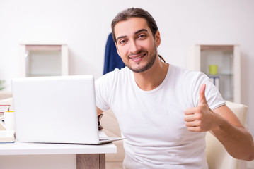 Young male student preparing for exams at home