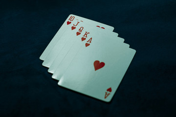 Royal flush of hearts. Winning poker hand on a dark table. Poker game concept