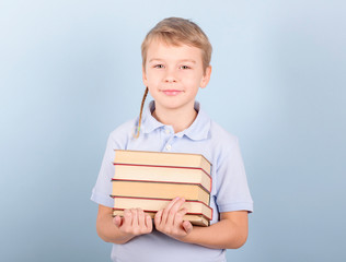 a boy reads a book on a blue background, a concept of education, school and love reading