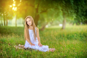 Portrait of a cute girl in a beautiful park at sunset. Children relax and walk outdoors. Childhood.